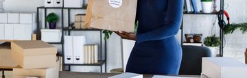 Woman packing boxes in a modern office space.