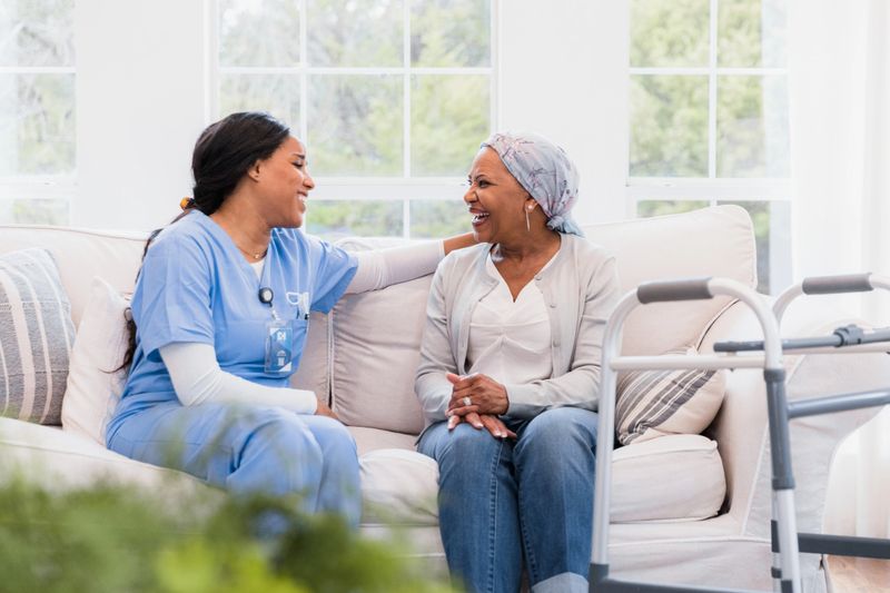 The hospice nurse sits and talks with her cancer patient to make a bond.