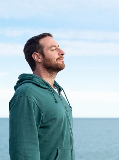 Man on beach feeling peaceful and relaxed following his hypnotherapy session for anxiety in Matlock