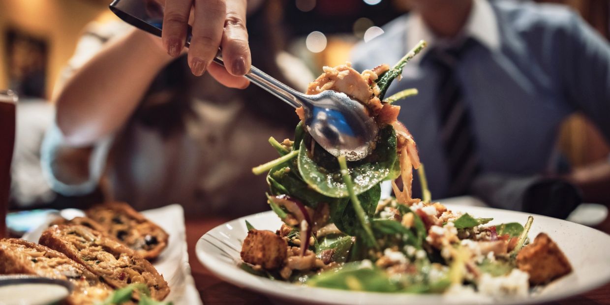 Serving a fresh spinach salad with toppings.