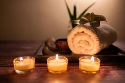 Relaxing massage setup with candles, towel, and spa decor for a calming treatment