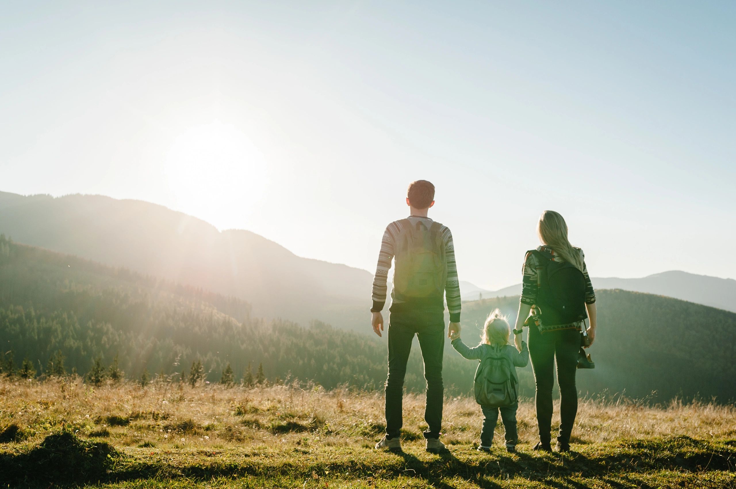 Family hiking in the mountains at sunrise.