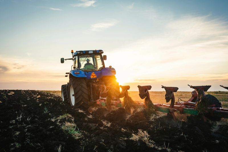 Farmer in tractor preparing land with seedbed cultivator . Agriculture concept.