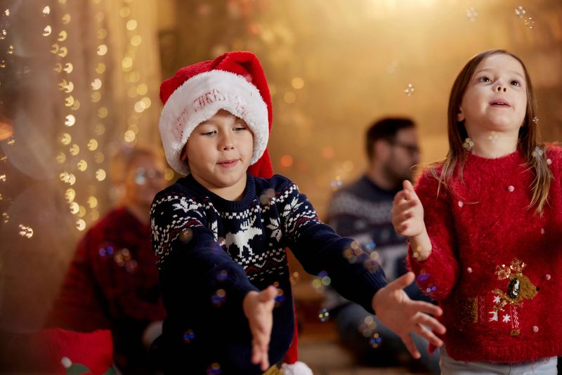 Little brother and sister having fun during New Year's Eve at home. Focus is on boy.