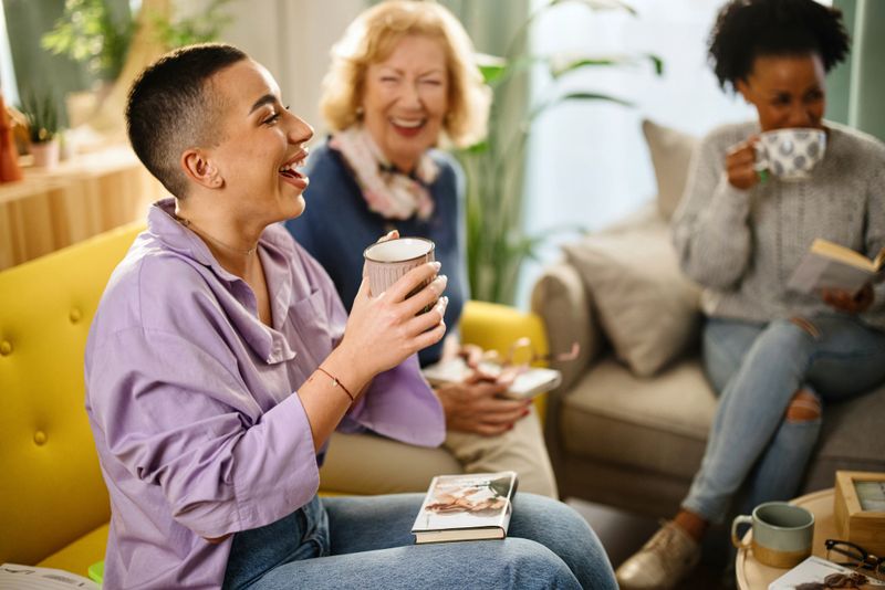 Small group of people with a mixed age range talking during a book club meeting.