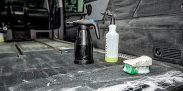 Cleaning supplies on a car floor.