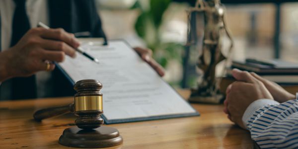 Legal consultation with documents and gavel on table.