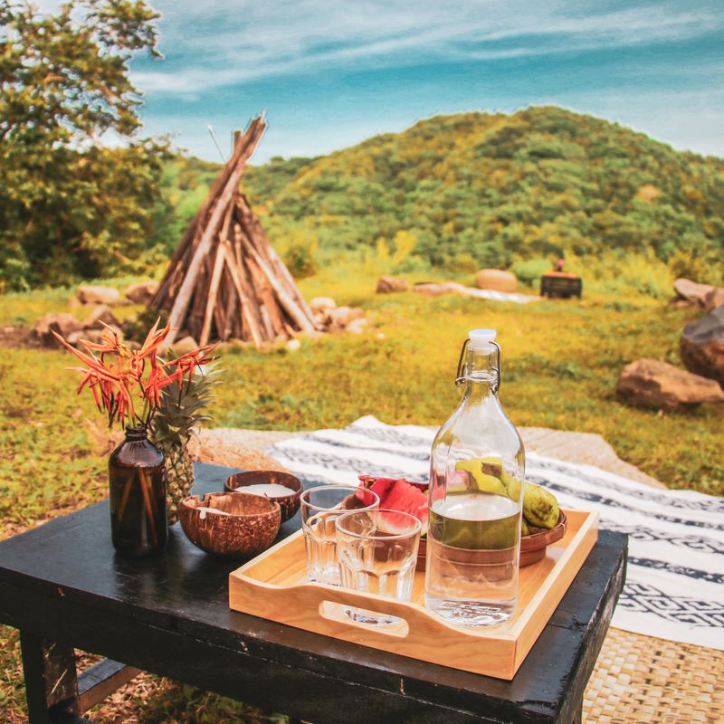Picnic on n a hill with a view of Selong Belanak lagoon. decoration, blankets, flowers pineapple, coconut bowls, ocean view. Relaxed enivorment