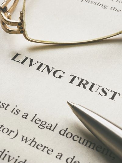 Legal document titled 'Living Trust' with glasses and a pen nearby.