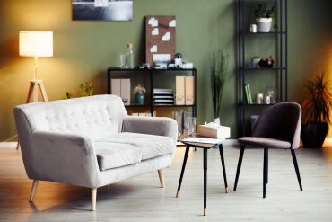 Cozy living room with modern sofa, chair, and warm lighting.