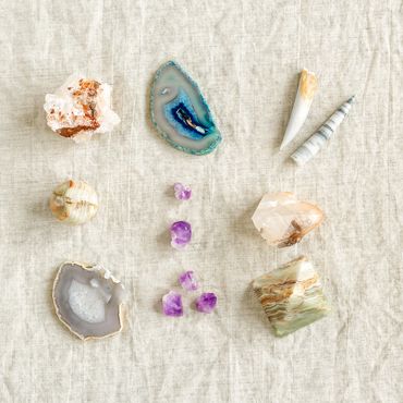 A collection of various crystals and stones arranged on a textured fabric.