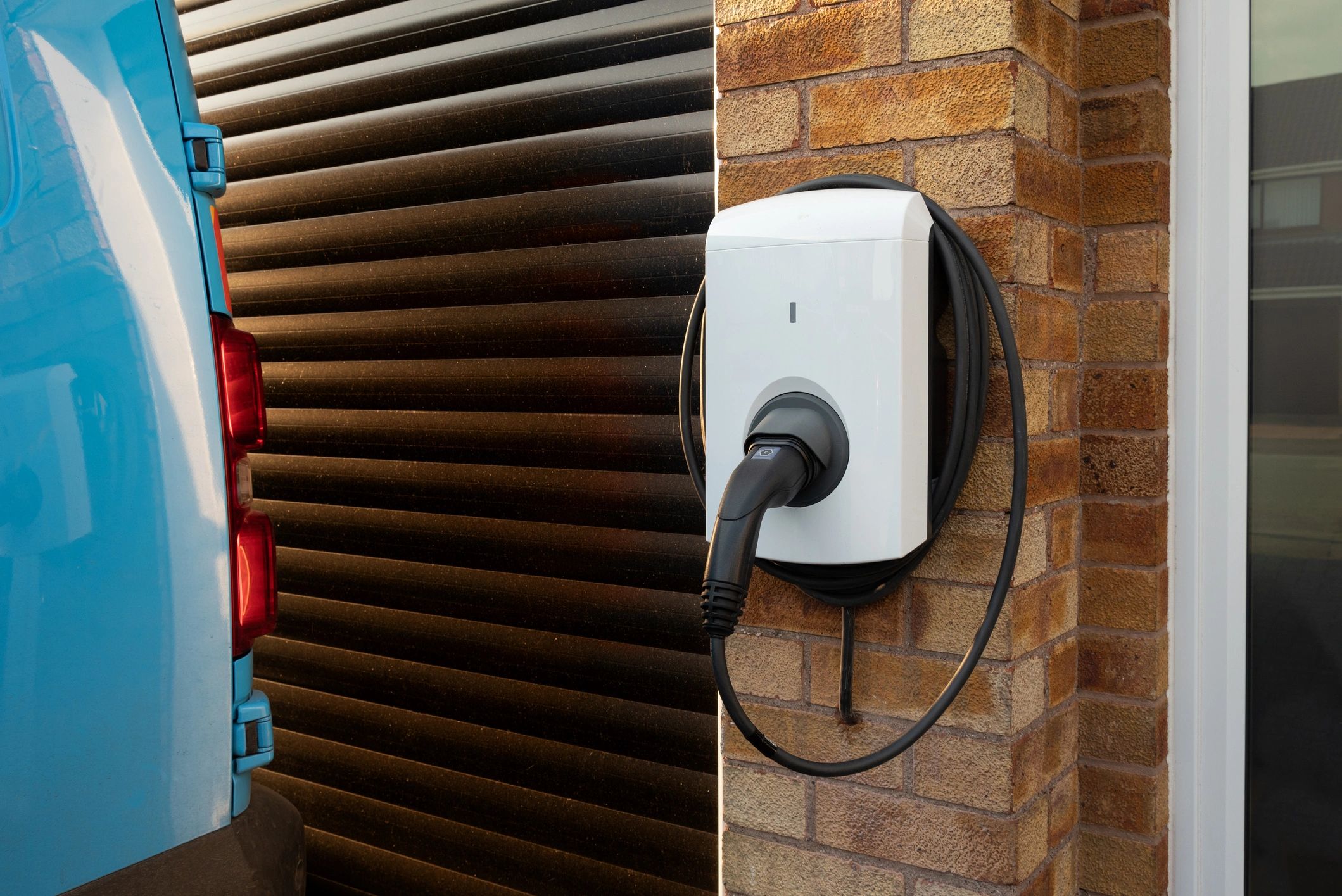 Wall-mounted EV charger installed on a home exterior.