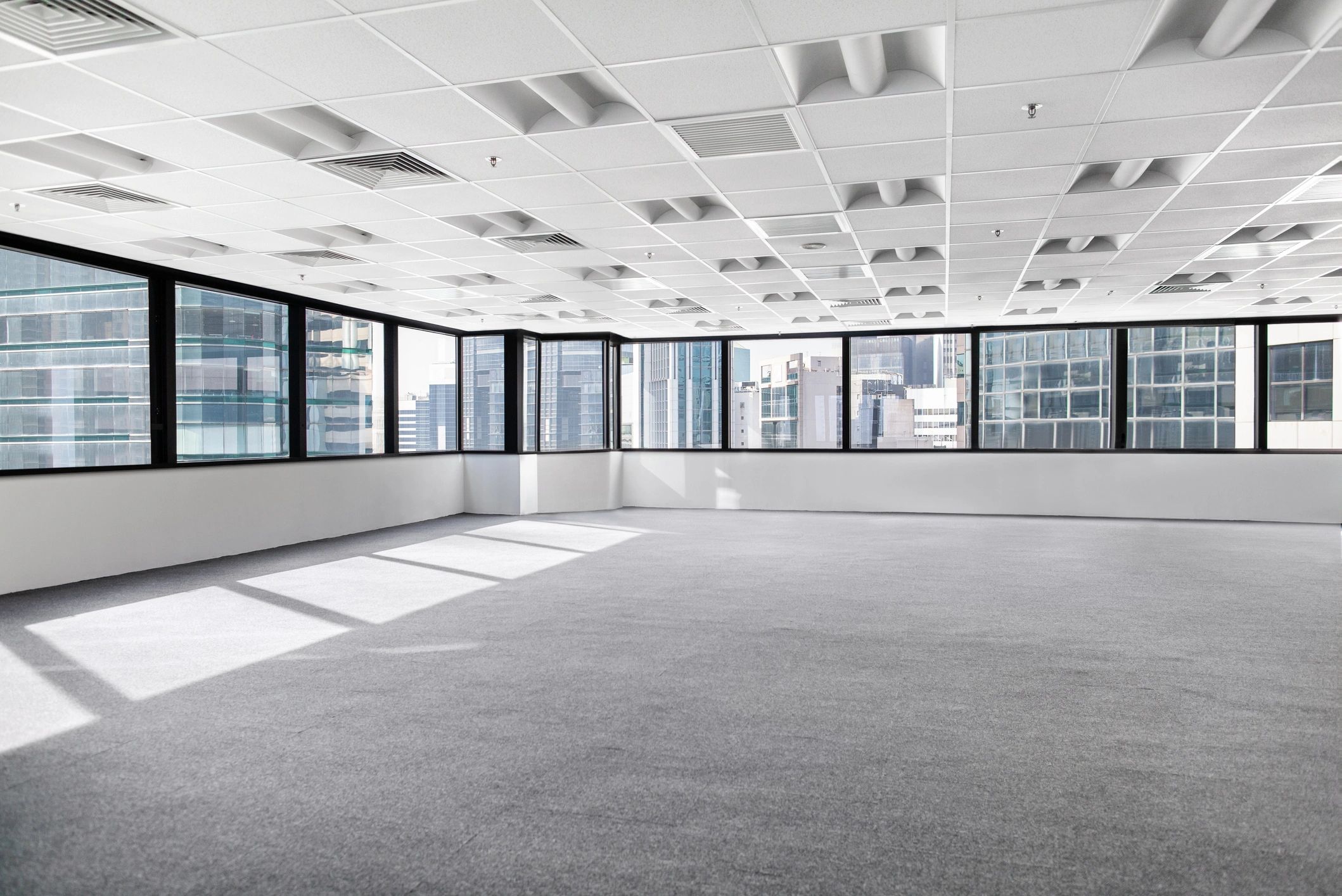Empty modern office space with large windows and city views.