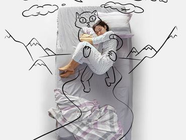 A child sleeps peacefully on a bed with playful cat doodles around.