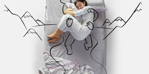 Woman sleeping on a bed with a drawn cat and mountain scenery around her.