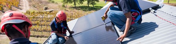 Solar panels installed in an open field beneath a clear sky.