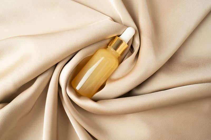 A vitamin C serum or natural essential oil lying on a beige fabric