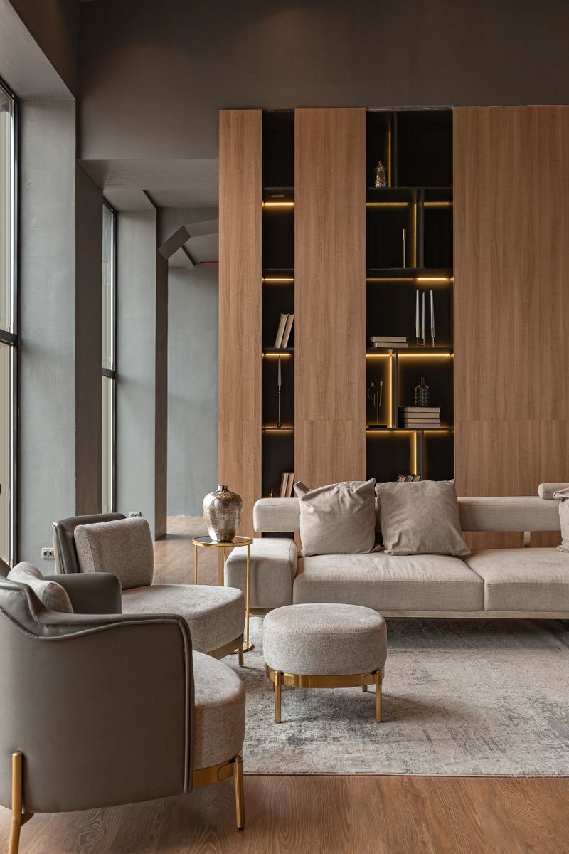 living room, marble wall fireplace and stylish bookcase in chic expensive interior of luxury country house with a modern design with wood and led light, gray furniture with gold elements