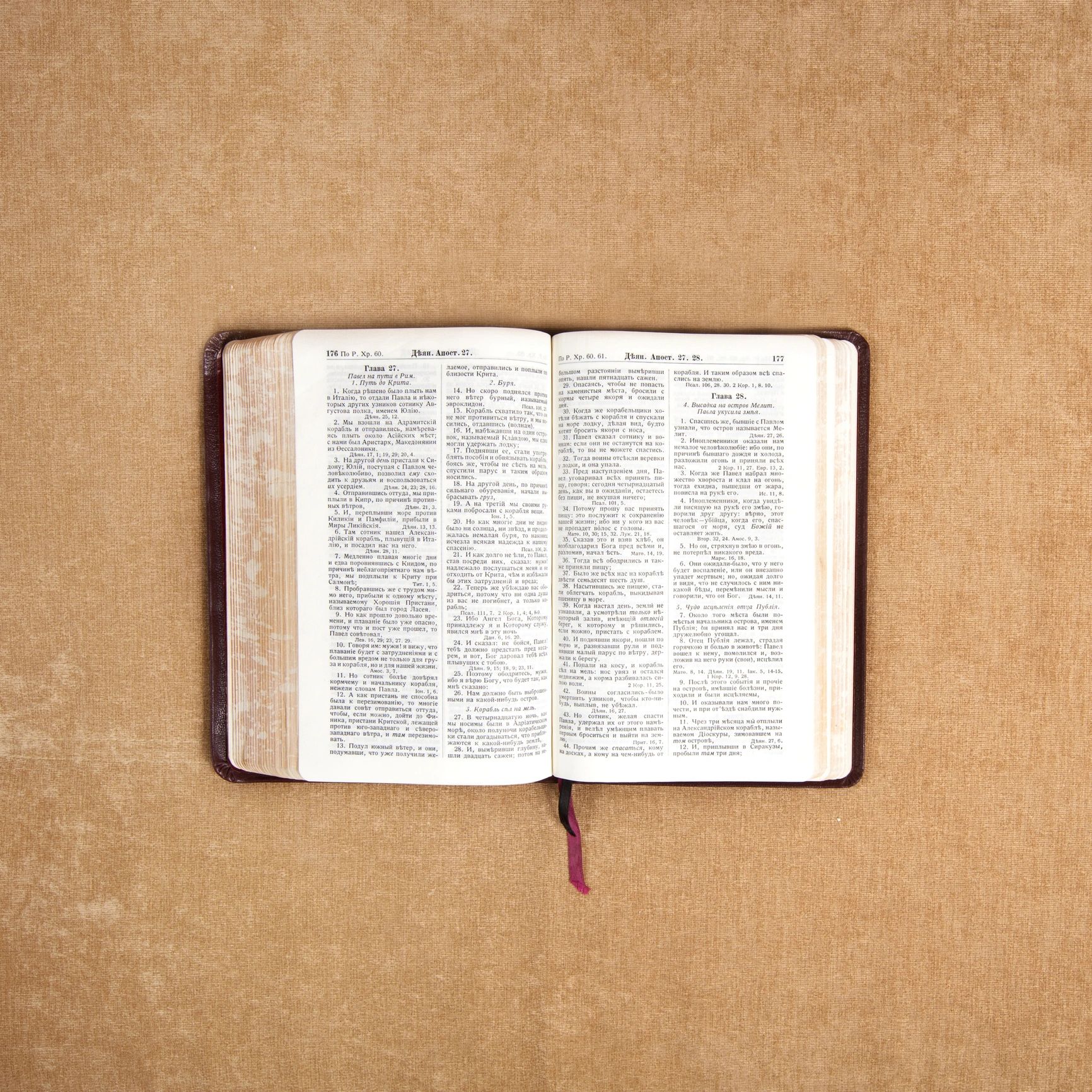Open book with text in Russian on a textured brown surface.