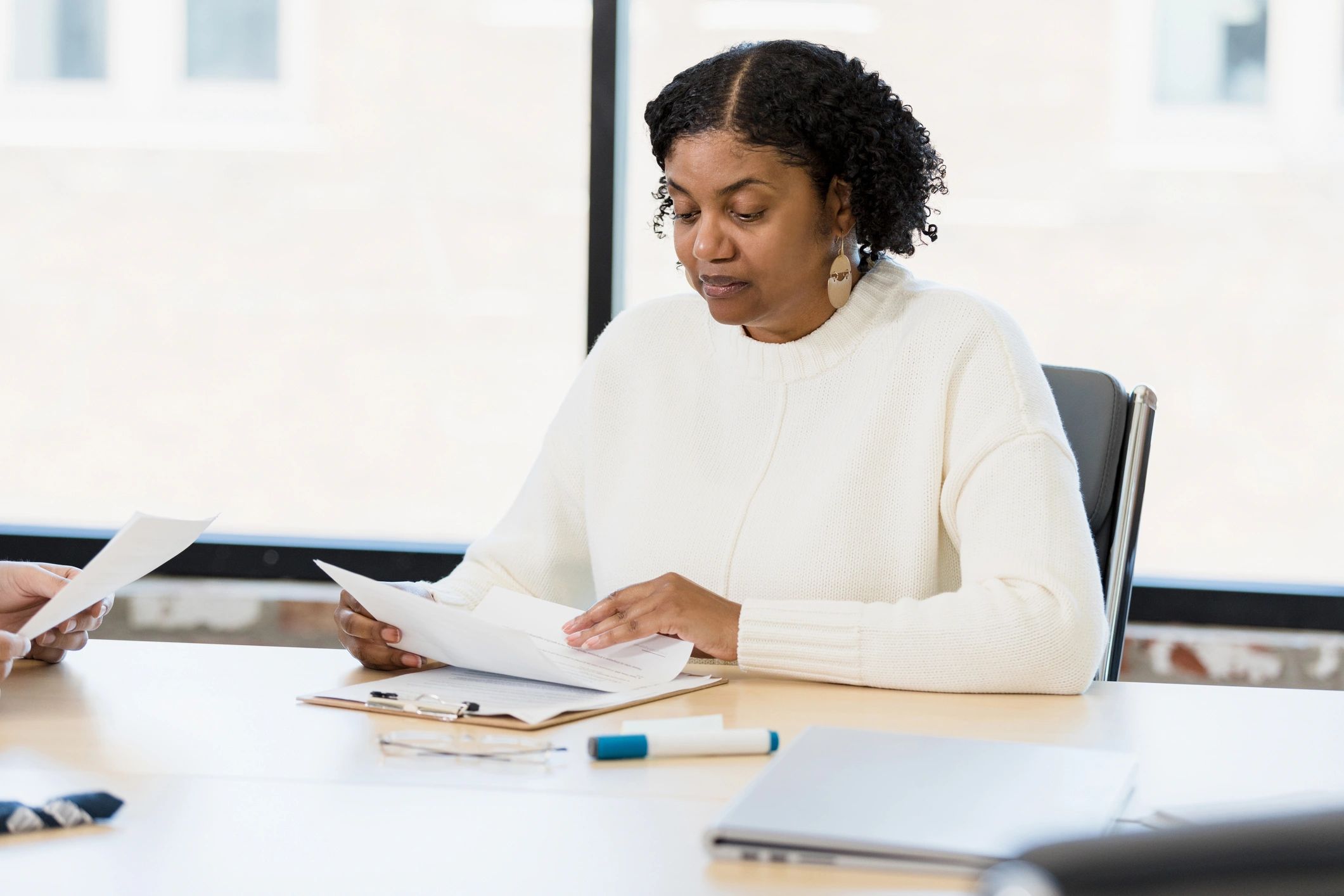 Woman reviewing application paperwork at a conference table