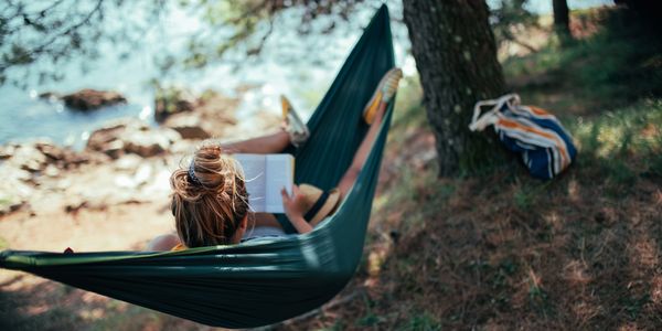 Woman in a hammock reading a book