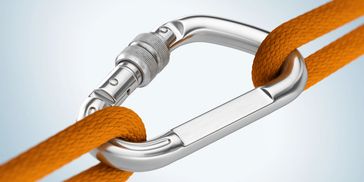 A silver carabiner securing two orange ropes tightly.