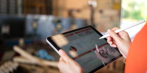 Person using stylus on tablet showing data charts.