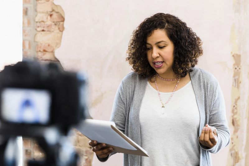 The young adult woman stands in front of the camera to audition for the commercial.