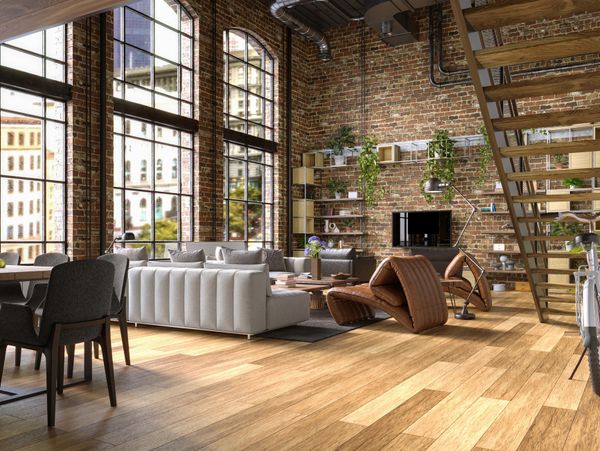 Spacious loft with exposed brick walls, large windows, and modern furniture.