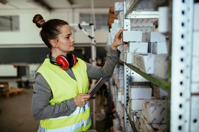 Worker organizing boxes in warehouse.