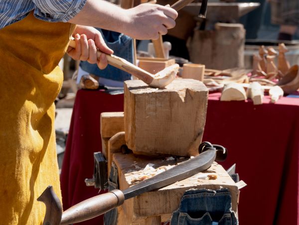 Person carving wood with a mallet and chisel.