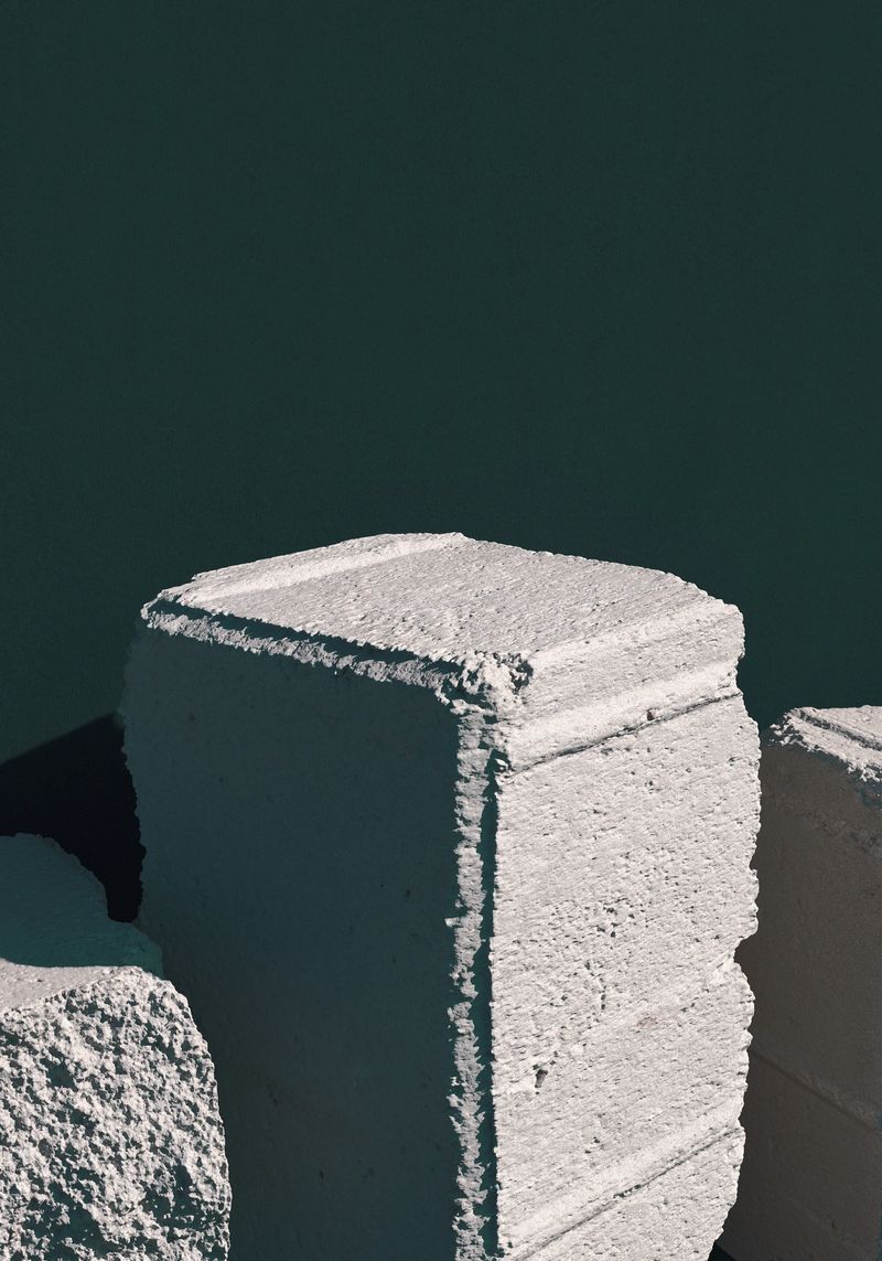 Shaded concrete bricks over dark background, rustic pedestal. 3d computer graphic template of displaying place for your products.