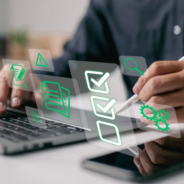Person using a stylus with digital checklist icons over laptop.