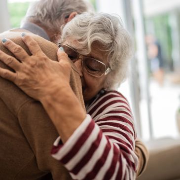 Senior couple embracing and supporting each other at home.