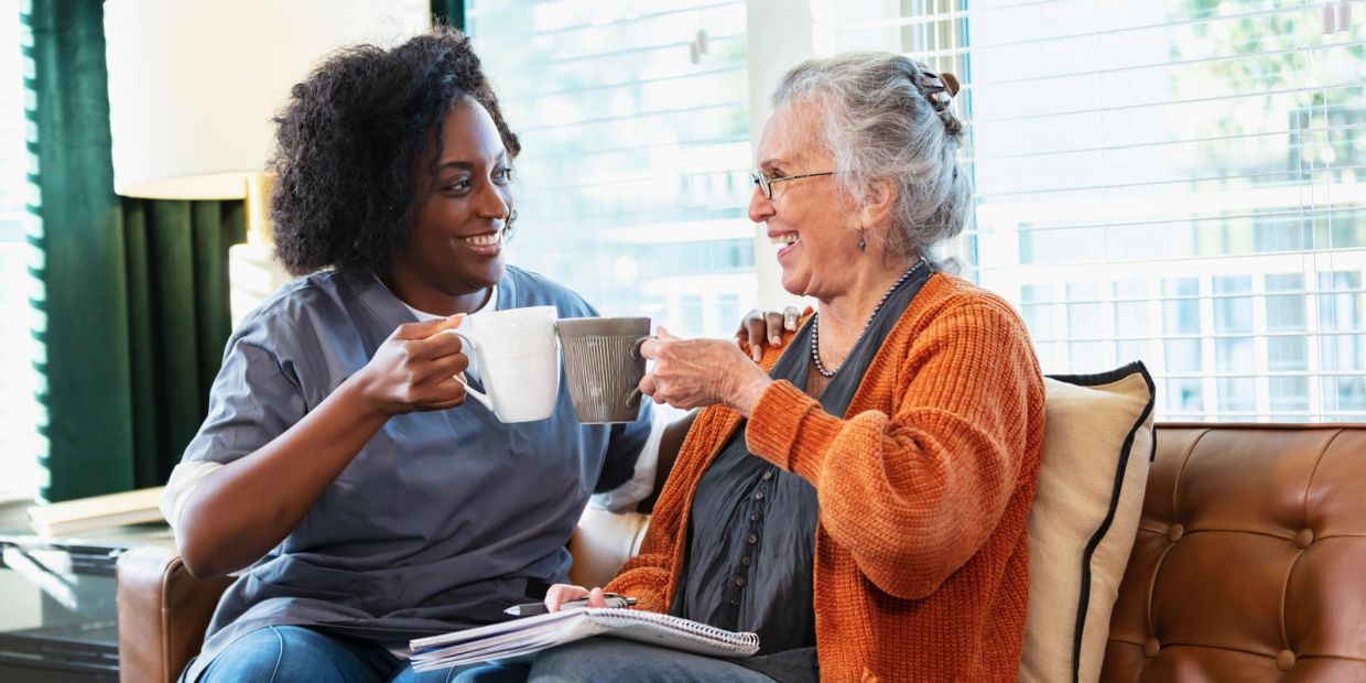 Two women sharing a joyful moment with coffee.