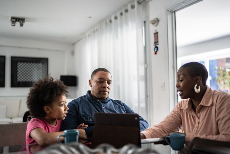 Professional consultant talking to customer and his daughter during home visit
