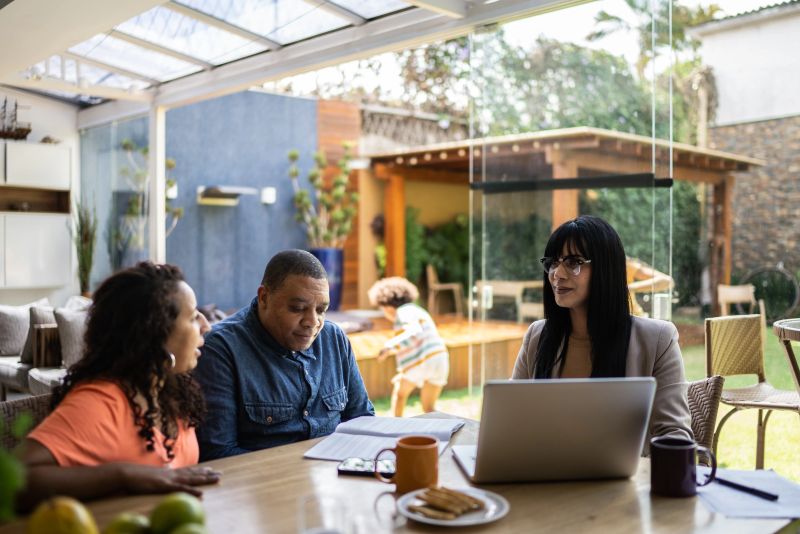 Transgender professional consultant doing a meeting with a couple during home visit