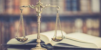 Golden scales of justice with an open book in the background.
