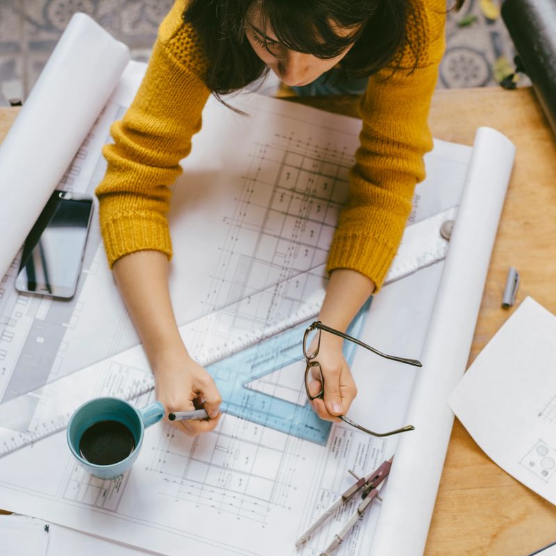 Real estate creative studio office. Top view of architect woman working on architectural project for interior design.