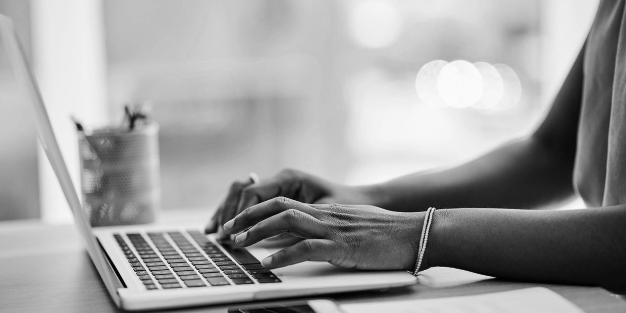 Person typing on a laptop keyboard.