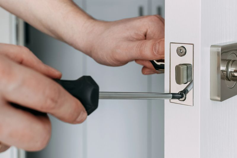 A locksmith repair the door lock in the room. A locksmith install the new deadbolt lock in the room. Selective focus.