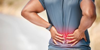 Person holding lower back in pain showing discomfort in the lower spine, chingford 