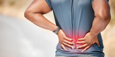 Person holding lower back in pain.