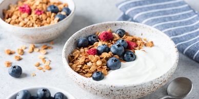 Bowl of yogurt with granola and blueberries.