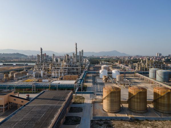 Industrial refinery complex with storage tanks and pipelines.