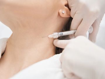 A person receiving an injection in the neck.