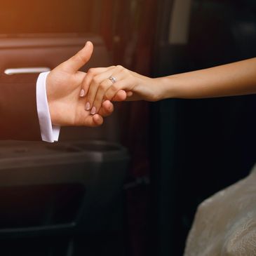 A groom gently holding the bride's hand with a wedding ring visible. Booking offered by Lady Limo EXParis. Styled with a classic limousine service. 