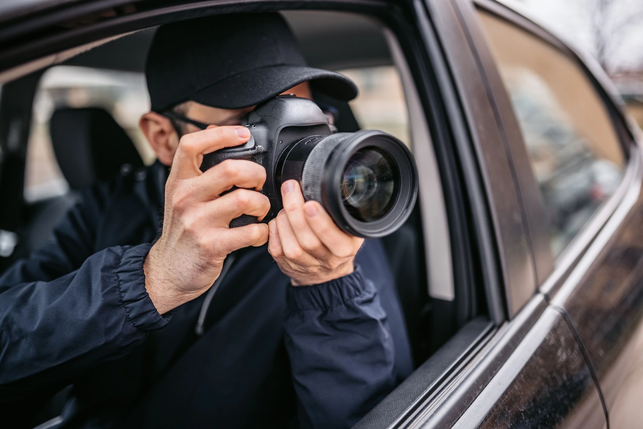 Person in a car taking photos with a DSLR camera.
