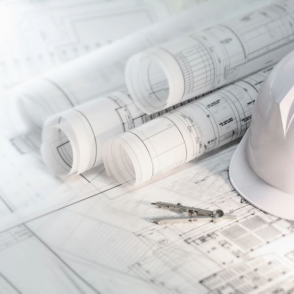 Architectural design blueprints and hard hat for Houston permit planning