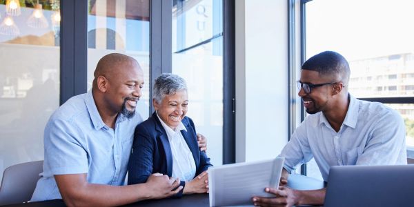 Couple happily consulting with a professional in an office.